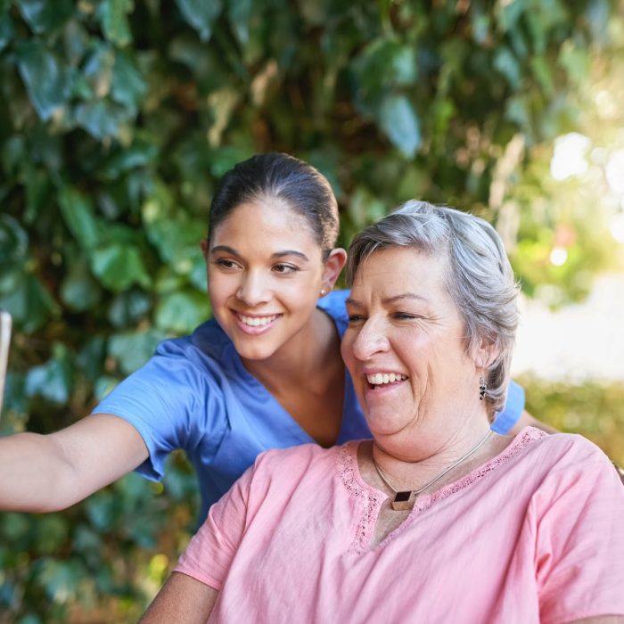 Cropped shot of a caregiver taking a selfie with a senior patient outside.
